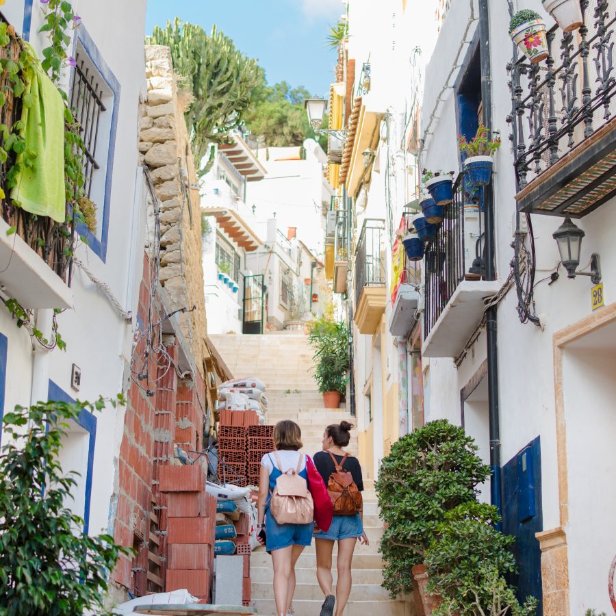 Two young women are walking on the street in Alicante, Spain. Lifestyle concept, leisure.
